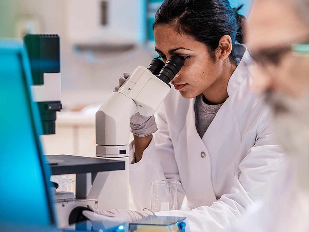 Image of scientist looking into a microscope